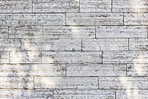 The texture of a gray stone wall made of rectangular marble blocks.