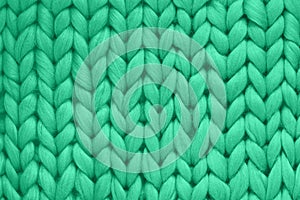 Texture of green wool big knit blanket. Large knitting. Plaid merino wool. Top view