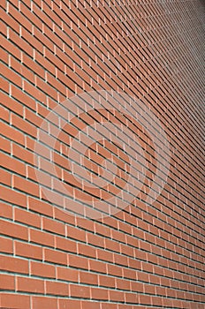 The texture of a high brick wall from a many rows of red bricks stretching into perspectiv