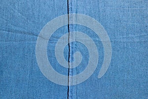 Texture of the inner side of a blue stretch denim fabric with the overstitch