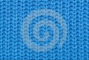 The texture of the knitted fabric in blue. Abstract background. Close-up