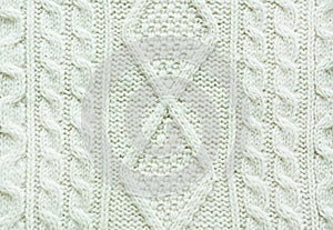 Texture of knitted handmade. Christmas white sweater close up. Wallpaper or abstract background.