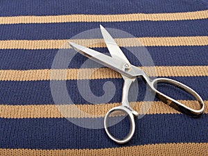 Texture of knitted wool cotton striped fabric and scissors.