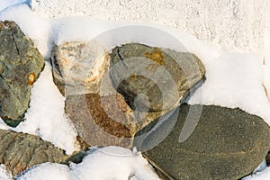 The texture of large stones on a snow background.