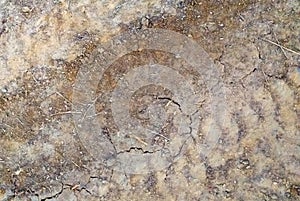 Texture of layers of dry gravel or mud, of different shades of brown with cracked soil. Abstract background of dry soil, Rough