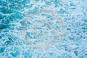 Texture Light blue surface of raging sea water with white foam and wave pattern.The azure surface of the ocean. Aerial photography