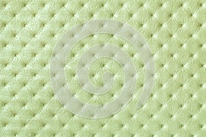 Texture of light green leather background with capitone pattern, macro