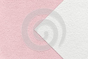 Texture of light pink paper background, half two colors with white arrow, macro. Structure of craft rose cardboard