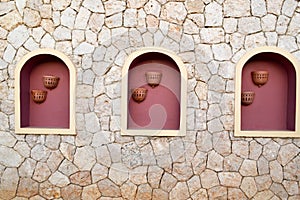 Texture light structure yellow wall cracks of natural sand stone, stone bricks three windows flower pots Arabic stylebackground