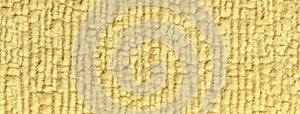Texture of light yellow fluffy woolen textile background from soft fleecy material, macro
