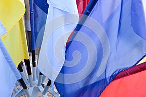 Texture of multi-colored festive red, blue, yellow flags made of fabric. The background.