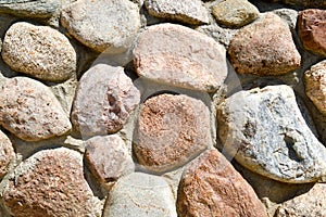 Texture of natural carved solid strong rough textured mineral gray brown stone cobblestone walls of the rock. Stone background