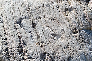 Texture of natural carved solid strong rough textured mineral gray brown stone cobblestone walls of the rock. Stone background