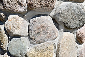 Texture of natural carved solid strong rough textured mineral gray brown stone cobblestone walls of the rock. Stone background