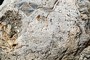 Texture of natural carved solid strong rough textured mineral gray brown stone cobblestone walls of the rock. Stone background