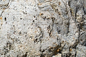 Texture of natural carved solid strong rough textured mineral gray brown stone cobblestone walls of the rock. Stone background