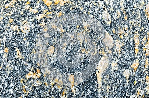 Texture of natural granite, black with yellow-orange impregnation.