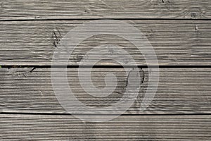 Texture natural wood deck board with knots, gray neutral color, top view close-up, photography background