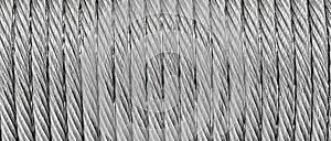 The texture of a new stainless steel cable wrapped in a spool. Abstract background.