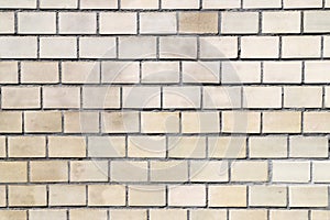 Texture of an old abd dirty wall made of beige rectangular tiles as a background