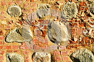 The texture of the old ancient medieval antique stone hard peeling cracked brick wall of rectangular red clay bricks and large