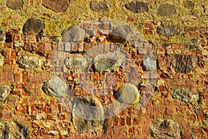 The texture of the old ancient medieval antique stone hard peeling cracked brick wall of rectangular red clay bricks and large