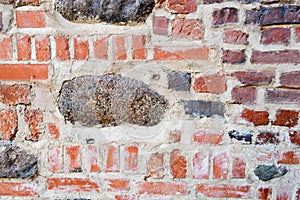 The texture of the old ancient medieval antique stone hard peeling cracked brick wall of rectangular red clay bricks and large