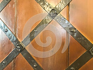 Texture of an old ancient medieval antique sturdy iron metal door with rivets and nails patterns. The background