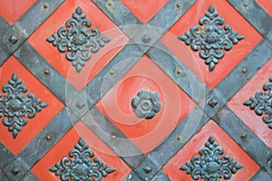 Texture of an old ancient medieval red antique sturdy iron metal door with rivets and nails patterns. The background