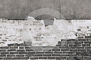 Texture of an old black brick wall with destroyed plaster