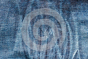 Texture of old blue jeans textile close up with fade