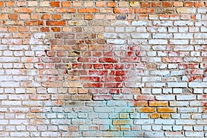 The texture of the old brick wall painted of blue, red, yellow and white colors.