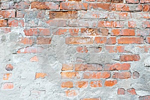 Texture of an old broken brick wall with cracks. Background of ancient brickwork with cement mortar