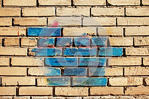 Texture of old colored bricks. Close-up of a red and green brick wall with painted bricks. Horizontal background with free space