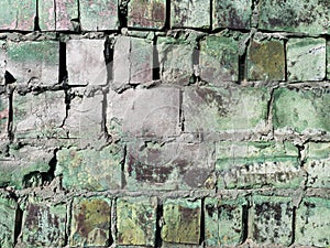 Texture of an old and dirty brick wall with the remains of paint