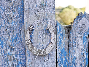 Texture of old iron horseshoe and wooden surface of the gate, in the village