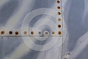 Texture of old jet plane with tiger camouflage and rusty screw