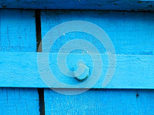 texture of old painted shabby rustic wooden fence made of planks, with rusty nails, hand-forged iron elements, grunge background