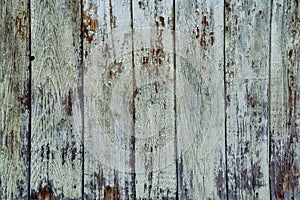 Texture of old painted wooden planks with peeling paint covered with cracks close-up