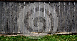 The texture of an old rustic wooden fence made of flat processed boards. Detailed image of a street fence of a rustic type made o