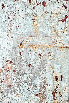 Texture of old rusty metal with keyhole, painted white which became orange from rust in some places. Horizontal texture of cracked