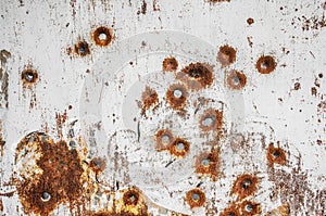 Texture of old rusty metal sheet with bullet holes on it