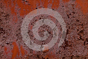 Texture of old rusty metal wall covered by old damaged red paint