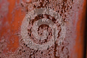Texture of old rusty metal wall covered by old damaged red paint