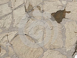 Texture of old stones of various forms with seams. Close up of shabby masonry. Stone wall from uneven different ancient friable