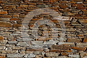 Texture of old wall built of dark red bricks and stone blocks