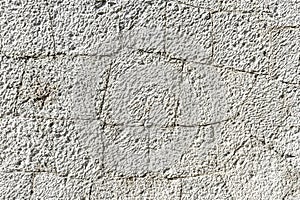 Texture of old white stone wall with cracks close up