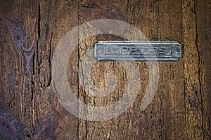 Texture of an old wooden door, rural texture with a recessed metal mailbox with the text in spanish cartas, letters photo