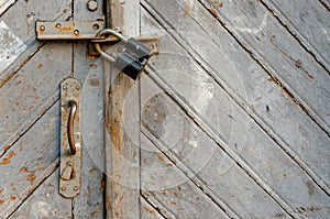 texture of an old wooden door. shabby paint. Closed door. Keyhole and door handle close-up. There is an old iron lock hinges