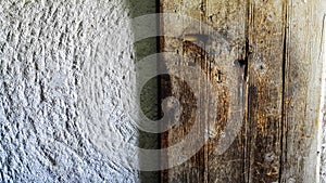 Texture of old wooden door and white sandstone wall